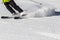 A skier on a ski slope turns with a whirlwind of snow from the skis.