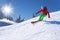 Skier skiing downhill in high mountains against blue sky