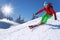 Skier skiing downhill in high mountains against blue sky