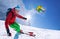 Skier skiing downhill in high mountains against blue sky