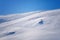 Skier skiing with helmet alone on the ski slope towards Matterhorn mountain on a beautiful sunny day in Switzerland