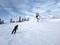 A skier slides down a mountain slope against the background of a sky covered with clouds