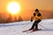 Skier on a slope at sunset