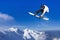 Skier Snowboarder jumping through air with sky in background