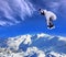 Skier Snowboarder jumping through air with sky in background