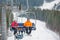 Skier and snowboarder riding up on ski lift