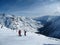 Skier standing on a slope. Girl in a light suit, the helmet and mask in skiing is to ski. In the background snow-capped mountains