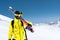 Skier standing on a slope. Man in a light suit, the helmet and mask in skiing is to ski. In the background snow-capped