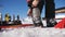 Skier stepping into the ski bindings with his ski boots on a sunny morning. Fixing the ski boot. Skiing close up.