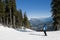 Skier stopped on trail, looking at mountains