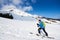 Skier tourist with backpack on background of bright blue sky and beautiful mountain panorama.