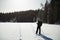 Skier tourist with a backpack on a frozen lake in the woods
