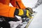 A skier wearing gloves switches ski bindings from ski touring mode to normal skiing mode. Close-up skitour preparation