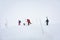 Skiers carries skis and equipment to the track on a slope for skiing on Mount Asahi Asahidake mountain during snowfall