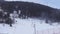 Skiers descending the ski slopes between mountains and with the snow cannons working to produce snow, Grandvalira