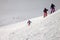 Skiers descent on snowy freeride slope and overcast misty sky