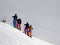 Skiers before downhill on snowy off-piste slope and overcast misty sky