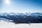 Skiers on a hill at the top of Blackcomb, 7th Heaven, with a view looking toward Whistler on a sunny day.