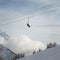 Skiers in ski lift high in snowy cloudy mountain