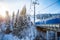 Skiers on the ski lift riding up at ski resort with beautiful background of forests