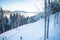 Skiers on the ski lift riding up at ski resort with beautiful background of forests