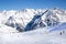Skiers skiing downhill, Tirol Tyrol Austria. Big Alps panorama. Winter day