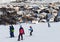 Skiers and snowboarder on snowy ski slope in high winter mountains
