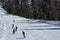 Skiers and snowboarders riding on a ski slope in mountain resort snowy winter