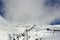 Skiers, snowboarders and tourists using the cable cars or ski lift to get to the top of a snow covered misty mountain