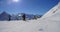 Skiers on sunny ski track in alpine mountains