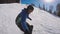 Skiing in the Alps in the winter. A man is rolling on a snowboard on the snow-covered trails of a mountain resort. The