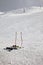 Skiing equipment: ski poles, skis on snowy slope