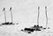Skiing equipment: ski poles, skis on snowy sunlit slope at winter