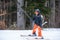 Skiing in the snow. One Asian girl sitting on ski lift by grabbing the rope and holding ski sticks. Vacation in Switzerland