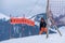 Skiing in the snow. One Asian girl sitting on ski lift by grabbing the rope and holding ski sticks. Vacation in Switzerland