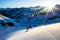 Skiing into the sunrise in the Talkeetna Mountains of Alaska. Man skiing down from the Snowbird hut Near Hatcher Pass