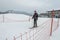 Skiing woman with brown hair entering ski lift area at the valley