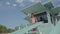 Skill shirtless athletic lifeguard in glasses speaking into a shout controlling situation on the beach. The man watching