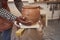 Skilled artisan preparing earthenware vessel for drying