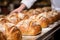 The skilled baker in the bakery carefully kneads the dough for baking bread.