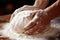 The skilled baker in the bakery carefully kneads the dough for baking bread.
