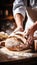 Skilled baker kneading dough in bakery, blurred background with space for text placement.