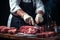 Skilled butcher cuts meat, frontal view, against a dark surface, showcasing precision