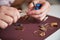 Skilled Caucasian female jeweler creating an earring