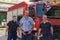 A skilled and dedicated professional firefighting team proudly poses in front of their state of the art firetruck