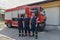 A skilled and dedicated professional firefighting team proudly poses in front of their state of the art firetruck