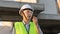 Skilled engineer inspects factory construction and uses a radio to chat with colleagues working on the field