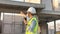 Skilled engineer inspects factory construction and uses a radio to chat with colleagues working on the field