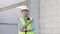 Skilled engineer inspects factory construction and uses a radio to chat with colleagues working on the field