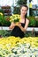 Skilled florist woman engaged in cultivation of plants of argyranthemum in greenhouse